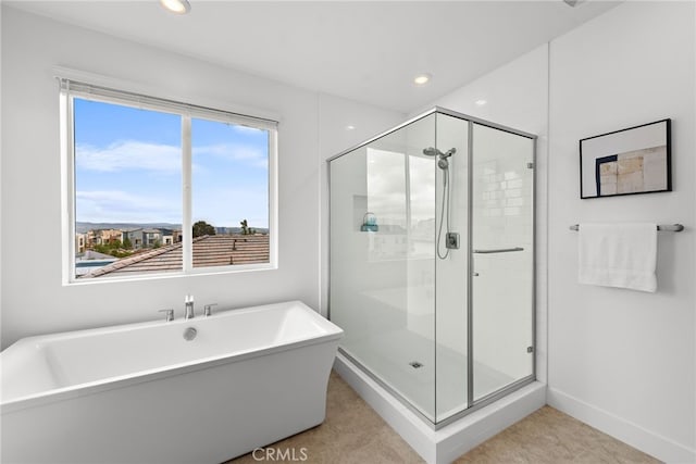 bathroom with a shower stall, a freestanding tub, recessed lighting, and baseboards