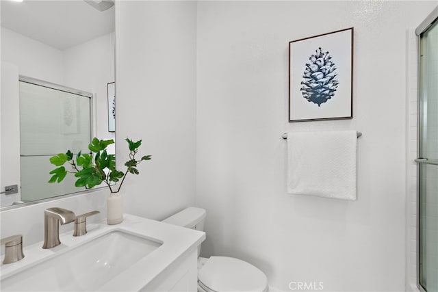 full bathroom featuring vanity, toilet, and a shower with shower door