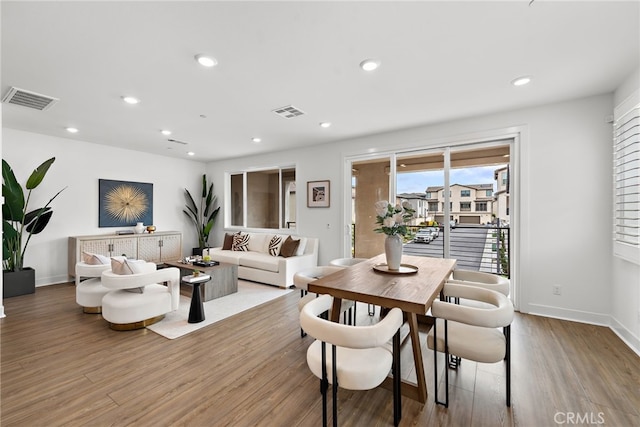 dining space with recessed lighting, wood finished floors, visible vents, and baseboards