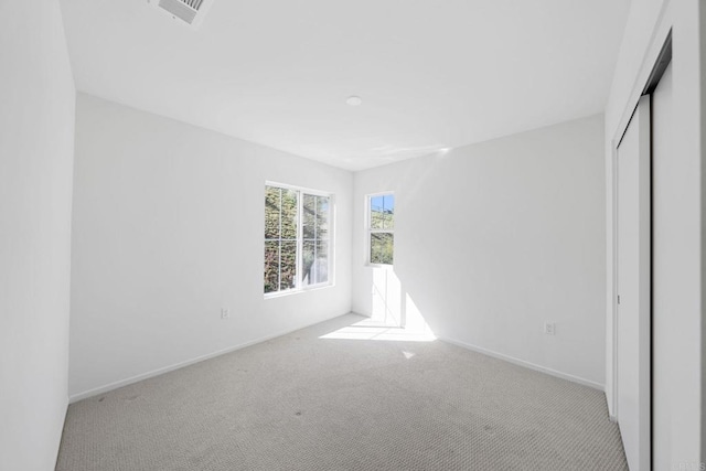 unfurnished bedroom featuring a closet, carpet flooring, visible vents, and baseboards