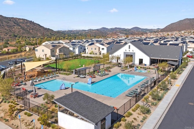 pool featuring a residential view, a mountain view, a patio, and fence