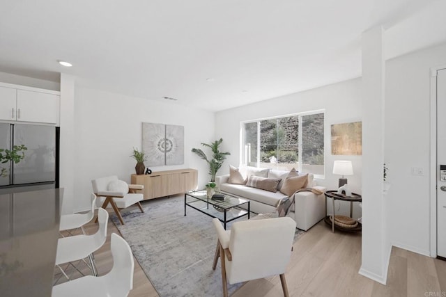 living area with light wood-style floors, baseboards, visible vents, and recessed lighting