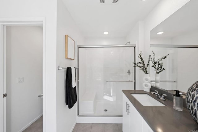 full bath with a stall shower, tile patterned flooring, vanity, and baseboards