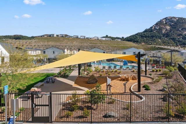 view of community with fence and a mountain view