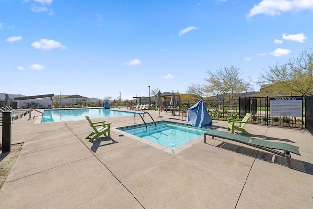 pool with a patio area and fence