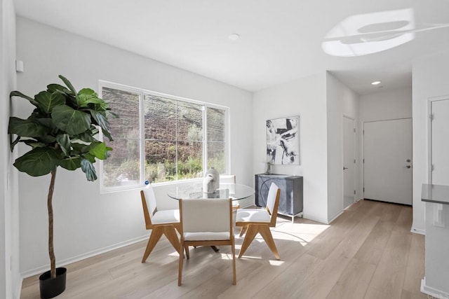 dining area featuring light wood-style flooring and baseboards