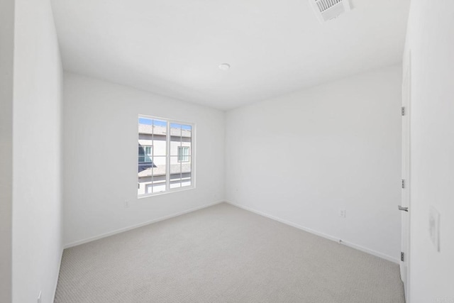 spare room featuring light carpet, baseboards, and visible vents