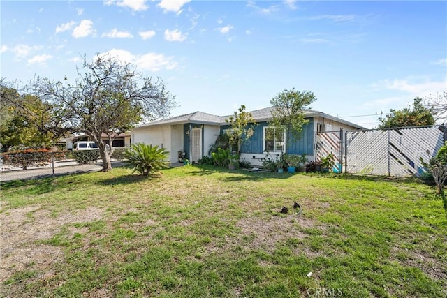 ranch-style home featuring a front lawn and fence