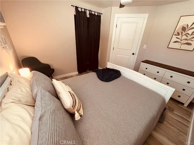 bedroom featuring dark wood-style floors and baseboards