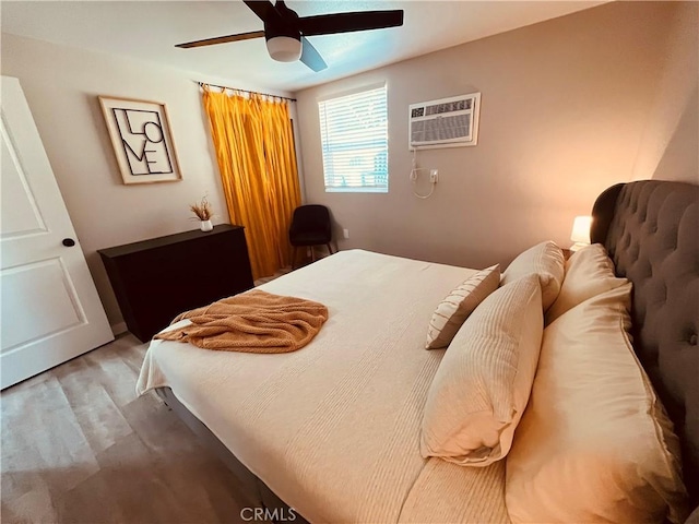 bedroom featuring a wall mounted air conditioner, ceiling fan, and light wood-style flooring