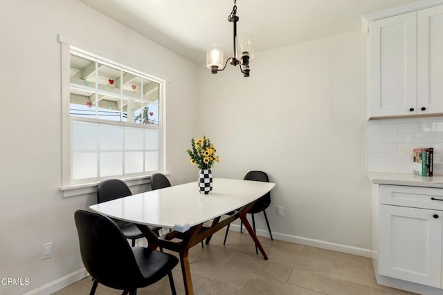 dining area featuring baseboards and a chandelier