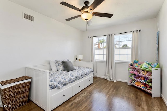 bedroom with baseboards, visible vents, and wood finished floors