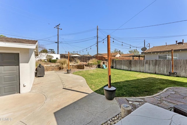 view of yard with a garage, a patio area, and a fenced backyard