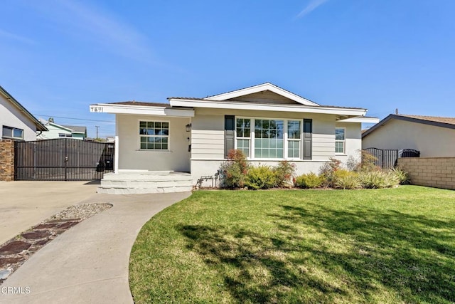 view of front of property featuring a front yard, fence, a gate, and stucco siding