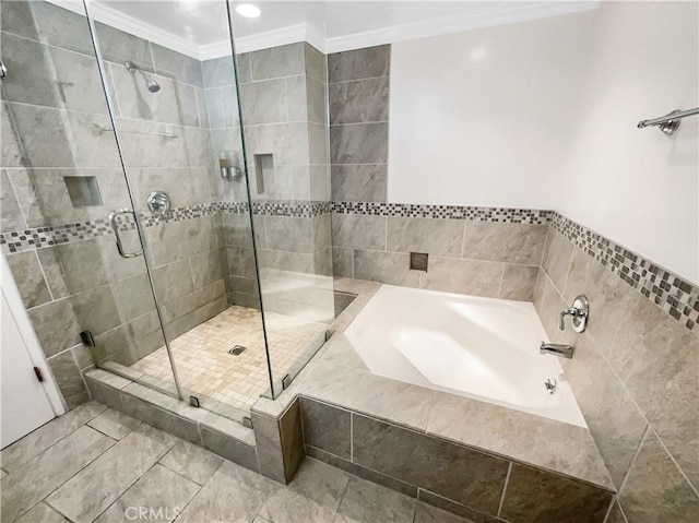 bathroom with ornamental molding, a stall shower, and a garden tub