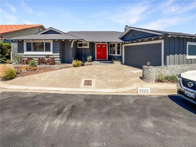 ranch-style home featuring a garage, driveway, and board and batten siding