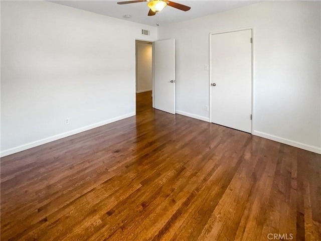 unfurnished bedroom featuring visible vents, dark wood finished floors, a ceiling fan, and baseboards