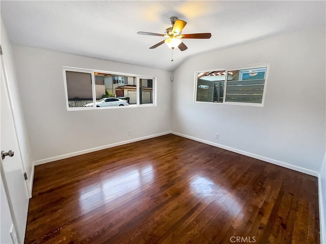 spare room featuring lofted ceiling, a ceiling fan, baseboards, and wood finished floors