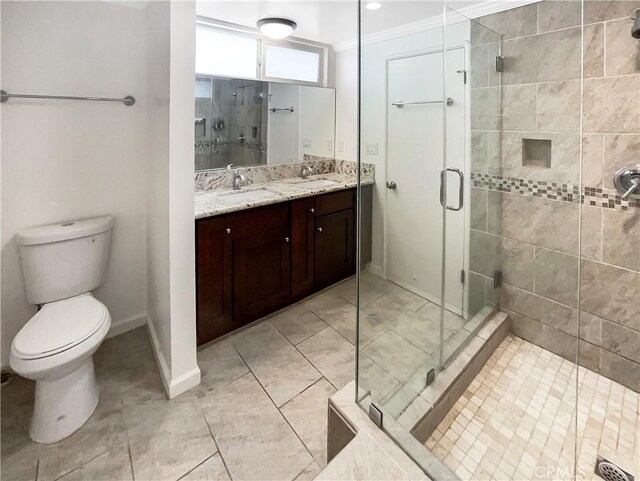 bathroom with toilet, vanity, baseboards, a shower stall, and crown molding