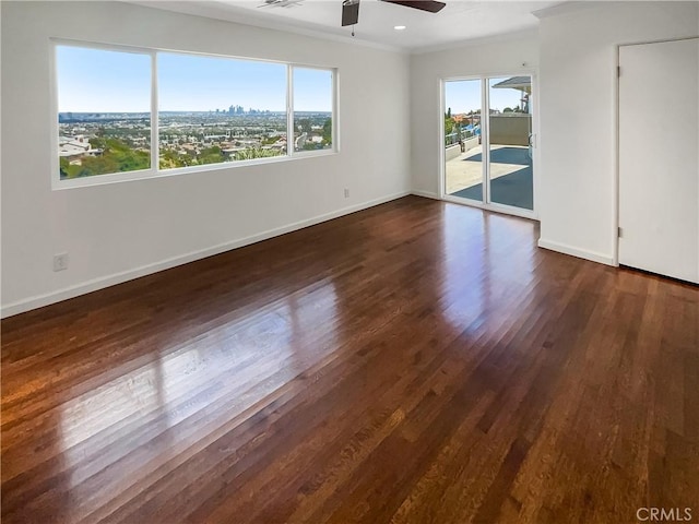 interior space featuring a ceiling fan, dark wood-style flooring, a healthy amount of sunlight, and crown molding