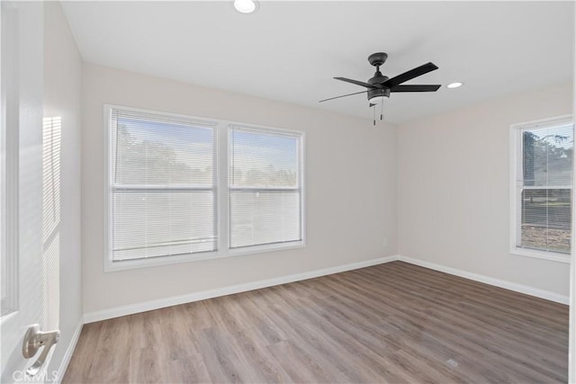 empty room featuring a ceiling fan, recessed lighting, baseboards, and wood finished floors