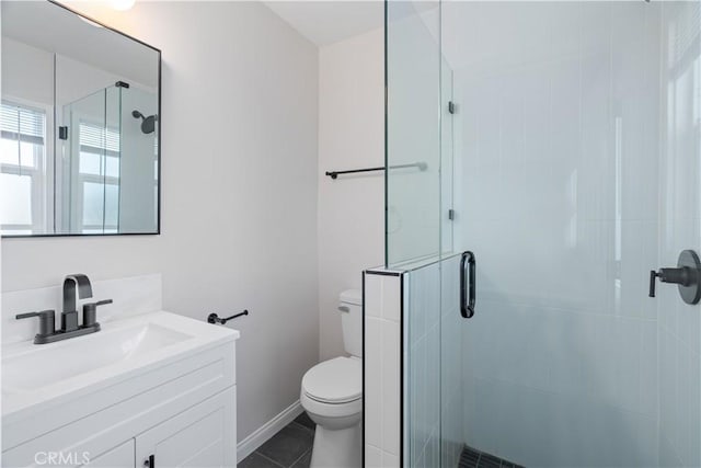 full bath featuring toilet, vanity, baseboards, a shower stall, and tile patterned floors