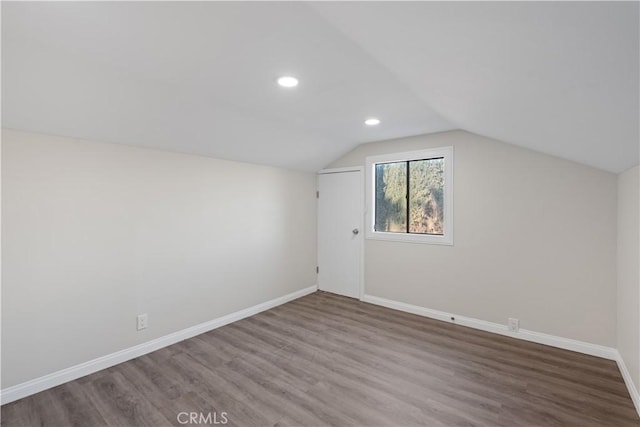 additional living space featuring recessed lighting, vaulted ceiling, baseboards, and wood finished floors