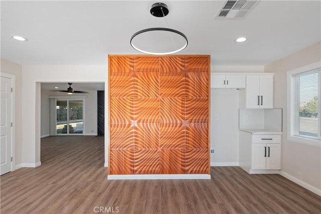 interior space with wood finished floors, visible vents, and baseboards