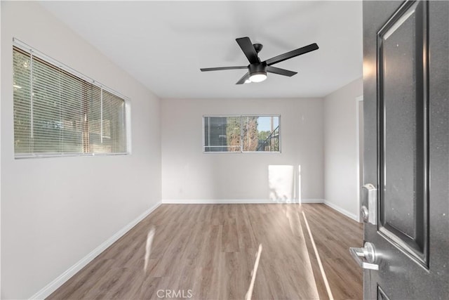 unfurnished room with ceiling fan, baseboards, and wood finished floors