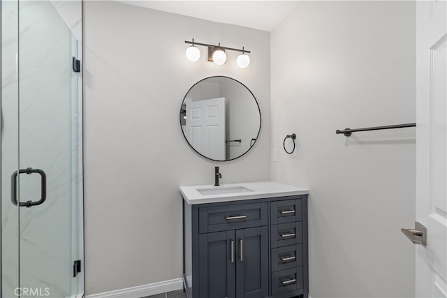 bathroom with a shower stall, vanity, and baseboards