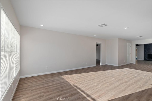 spare room featuring recessed lighting, visible vents, baseboards, and wood finished floors