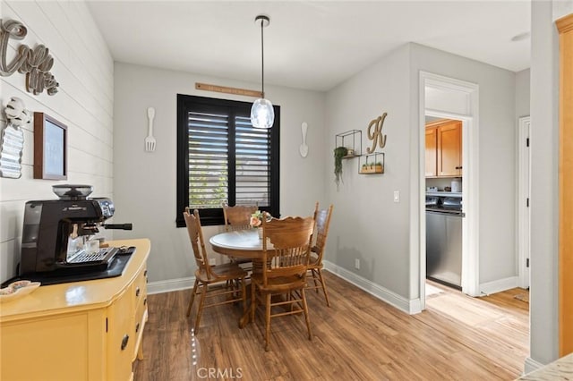 dining area with washer / dryer, light wood-style flooring, and baseboards