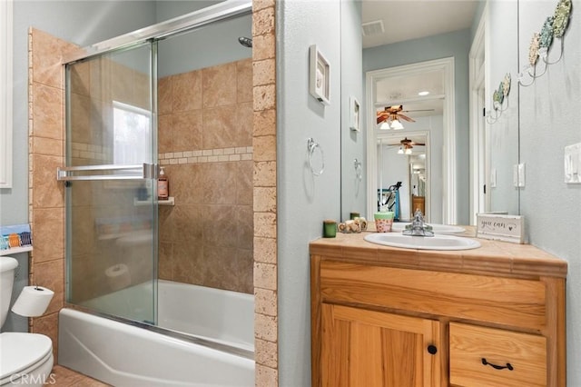 full bath featuring bath / shower combo with glass door, visible vents, toilet, ceiling fan, and vanity