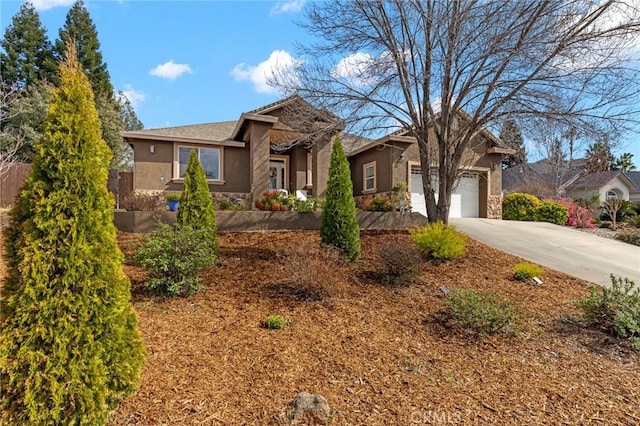 ranch-style home with a garage, stone siding, concrete driveway, and stucco siding