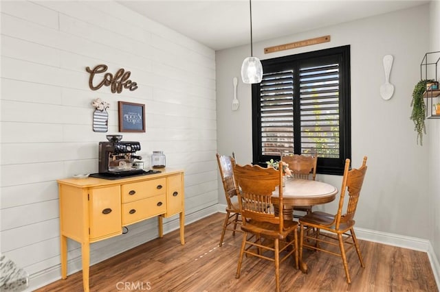 dining space featuring baseboards and wood finished floors