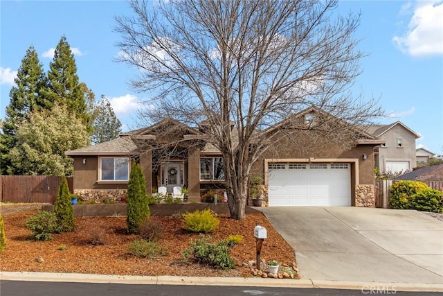 single story home with stone siding, fence, driveway, and an attached garage