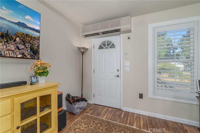 entrance foyer with a wall mounted AC, dark wood finished floors, and baseboards