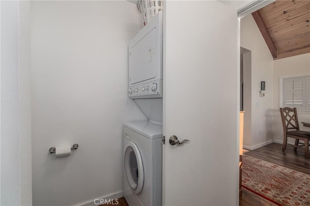 laundry area with wood ceiling, stacked washing maching and dryer, wood finished floors, laundry area, and baseboards