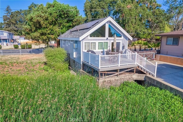 back of property with fence and a wooden deck