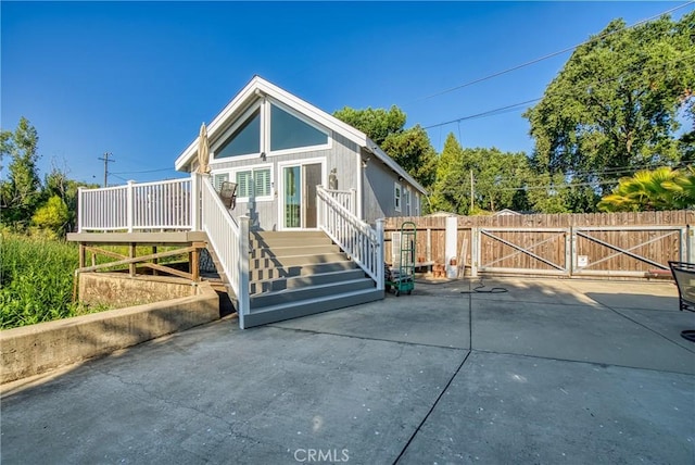 view of front facade with a gate, fence, and a wooden deck