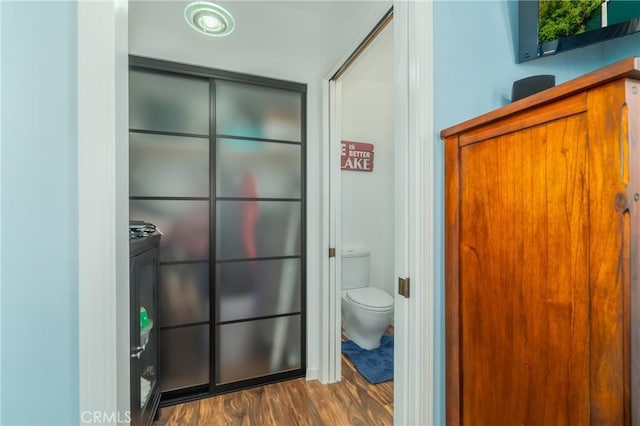 bathroom featuring wood finished floors and toilet