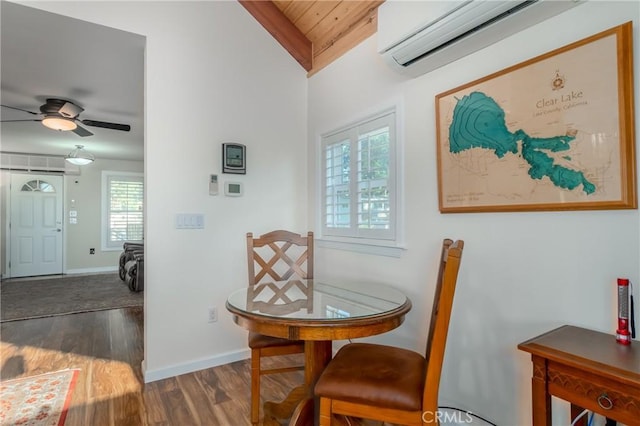 dining room featuring ceiling fan, a wall mounted AC, wood finished floors, and baseboards