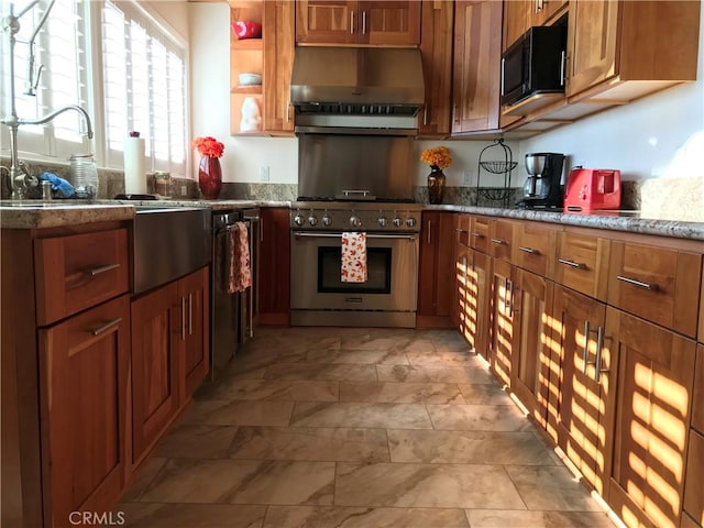 kitchen featuring brown cabinets, black microwave, a sink, high end stove, and under cabinet range hood