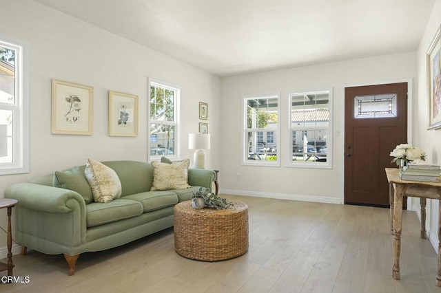 living area with light wood-style flooring and baseboards