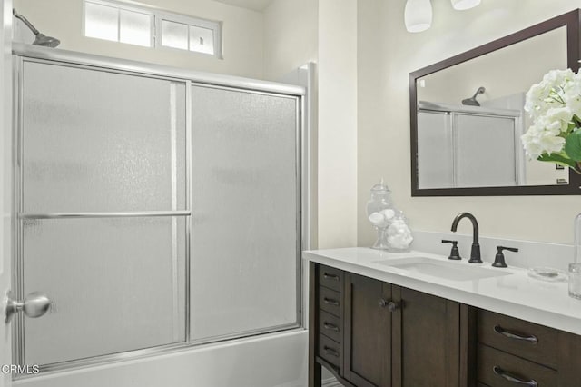 bathroom featuring vanity and shower / bath combination with glass door