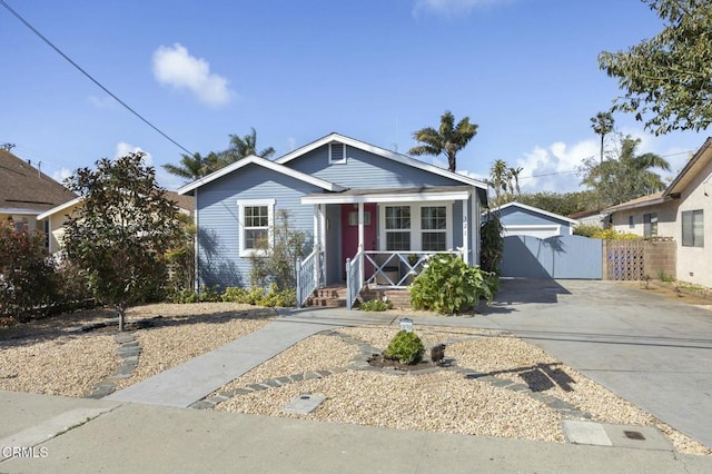 bungalow-style home with concrete driveway, a gate, fence, and a garage