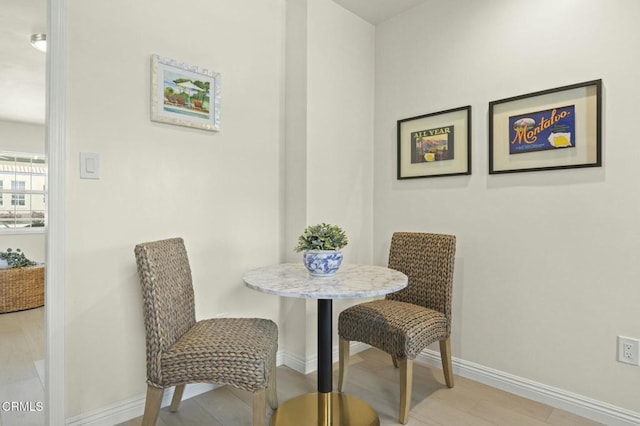 dining area with baseboards and light wood finished floors