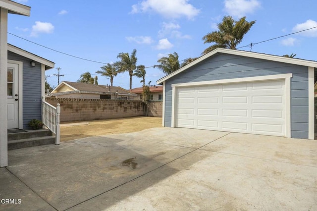 detached garage featuring fence