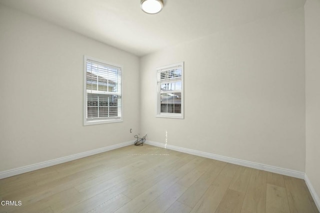 unfurnished room with baseboards and light wood-style floors