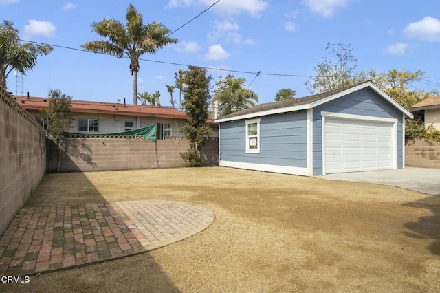 garage featuring driveway and fence